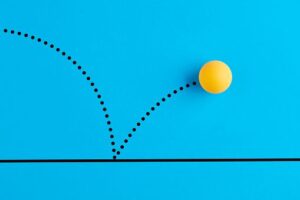 Table tennis ball is bouncing on blue background