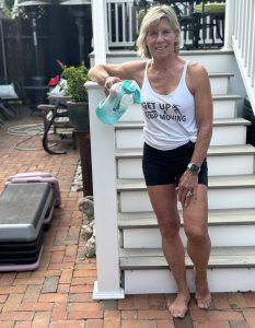 Polli standing on patio with water bottle