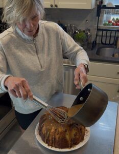 Polli pouring glaze on apple cake